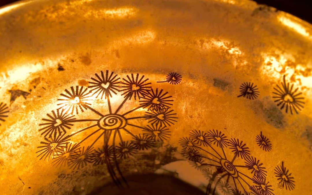 Kerzenschein im Gefäß mit goldenem Blumenmuster