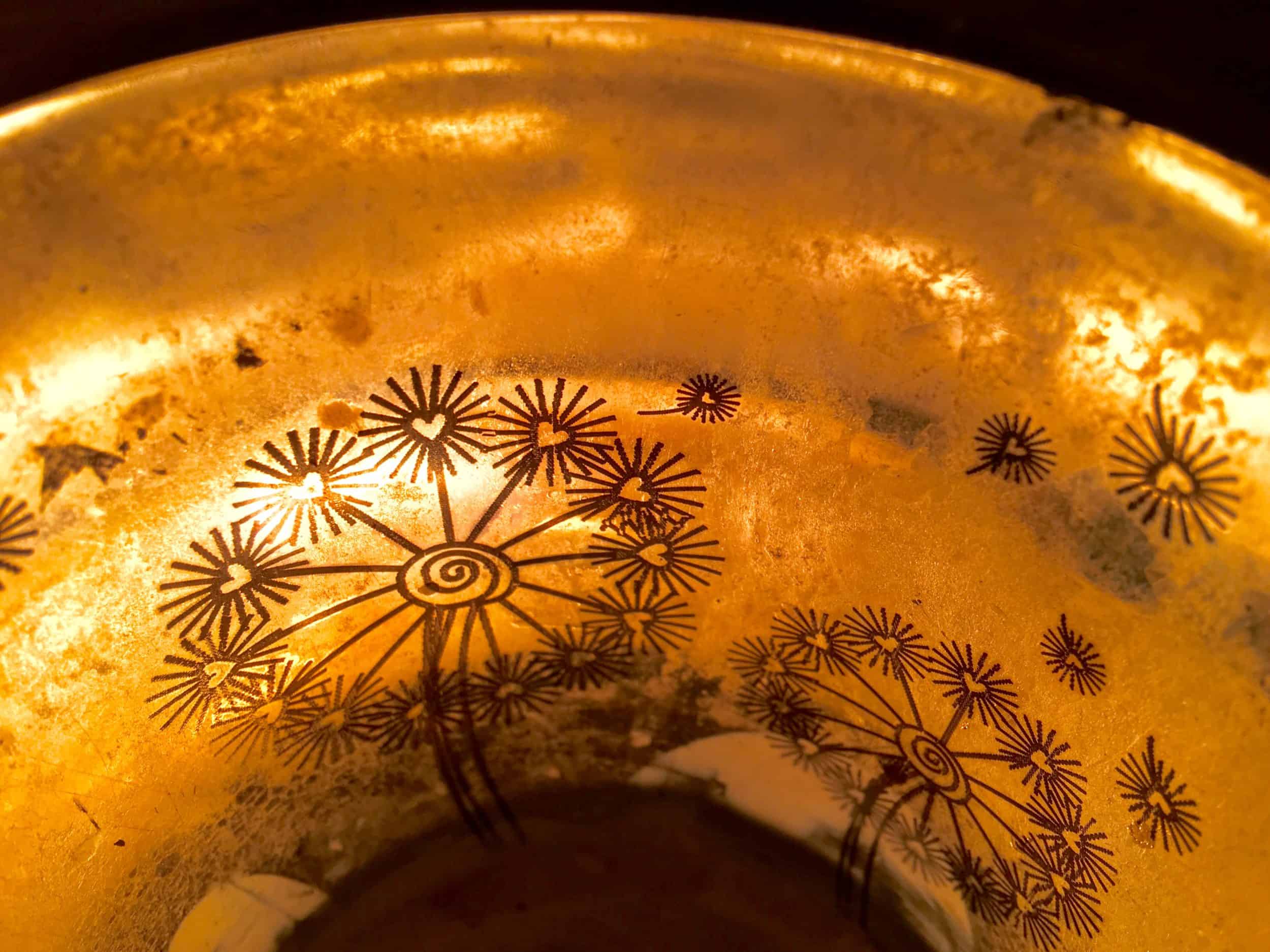 Kerzenschein im Gefäß mit goldenem Blumenmuster