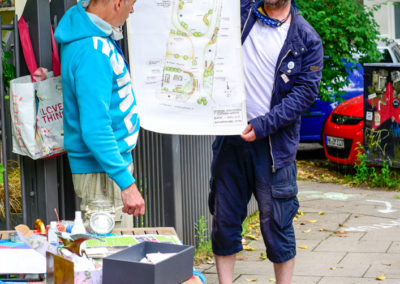 Stefan und Ralf zeigen den Plan zum Umbau der Grünanlage